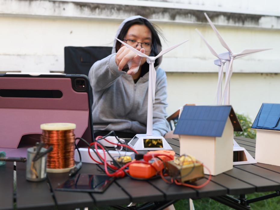 Student testing out a wind turbine model
