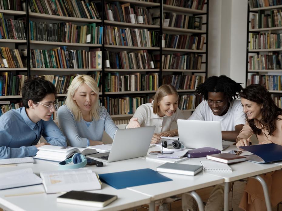 A group of students on their laptops in the library