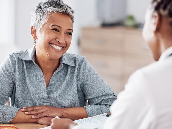 Smiling woman talking to healthcare professional