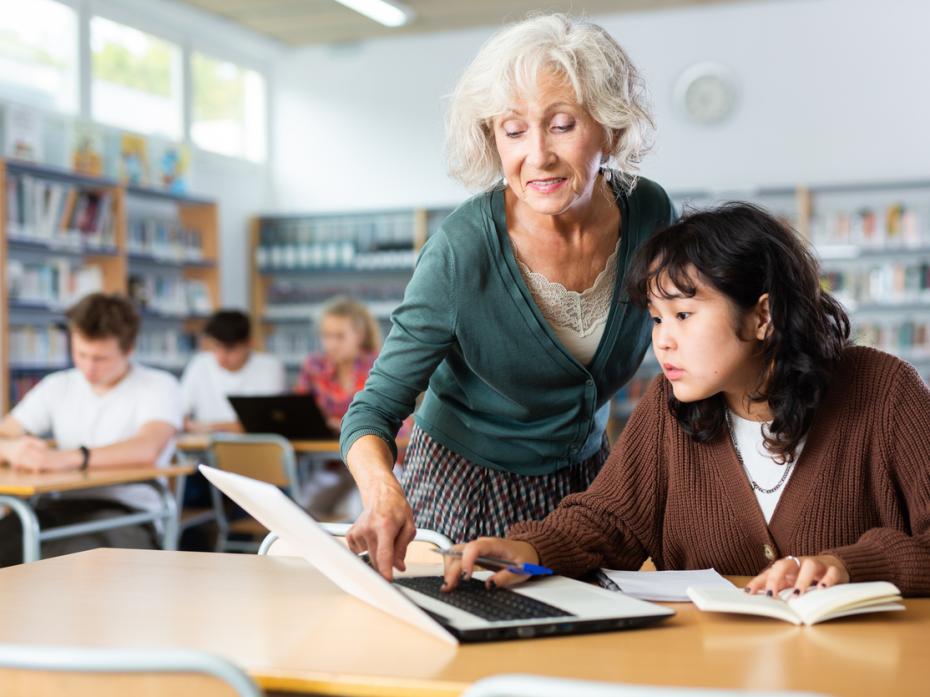 Teacher guiding a student through an exercies on their laptop