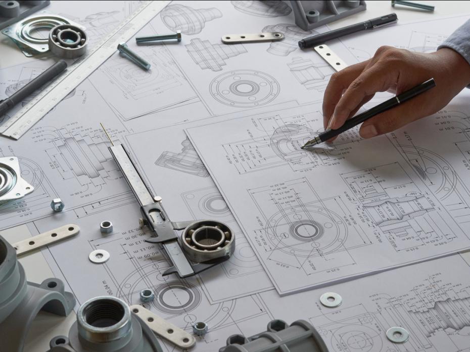 A hand sketching prototype designs amongst rulers and other tools