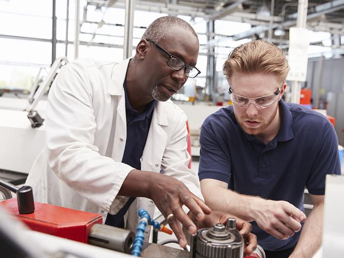Older engineer working with an engineering apprentice
