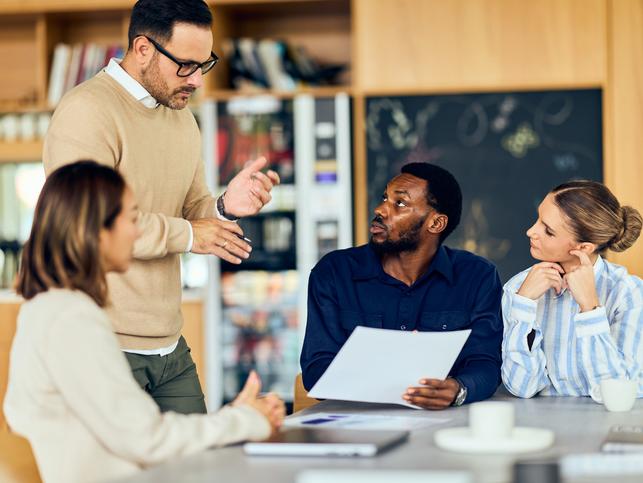 Academics discuss around a meeting table