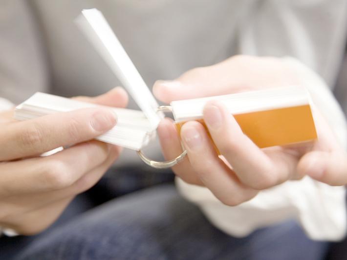 Close-up of hands flicking through flashcards