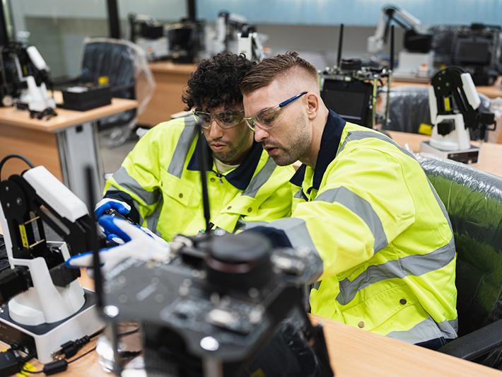 Two engineers in a robotics workshop