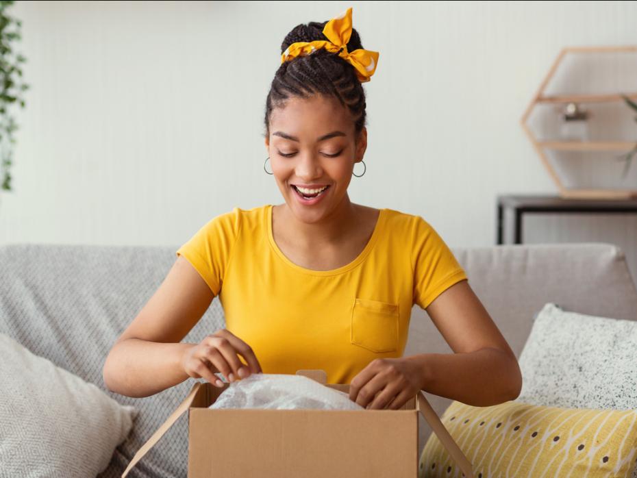A woman opening a package with a surprised expression on her face