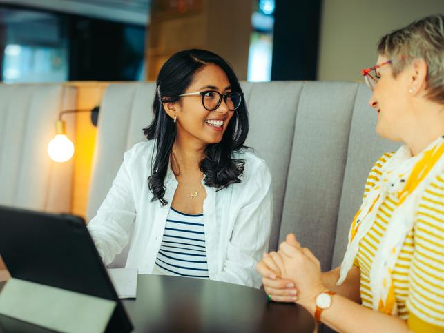 A supervisor and supervisee chat over a tablet