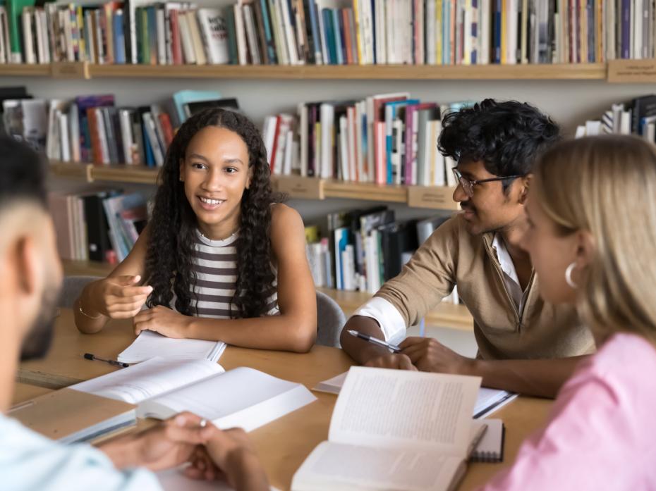 A group of students sitting at a table in the library