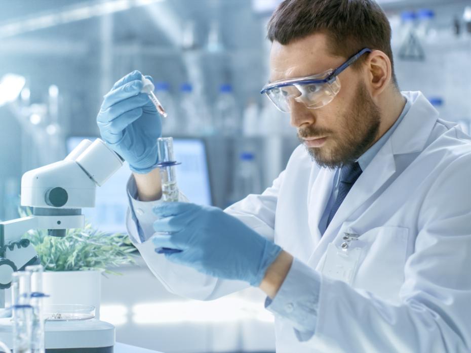A scientist filling a test tube in a lab