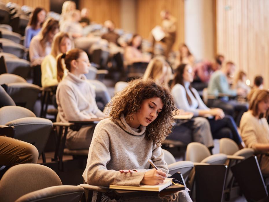 Students in a lecture hall working on essays