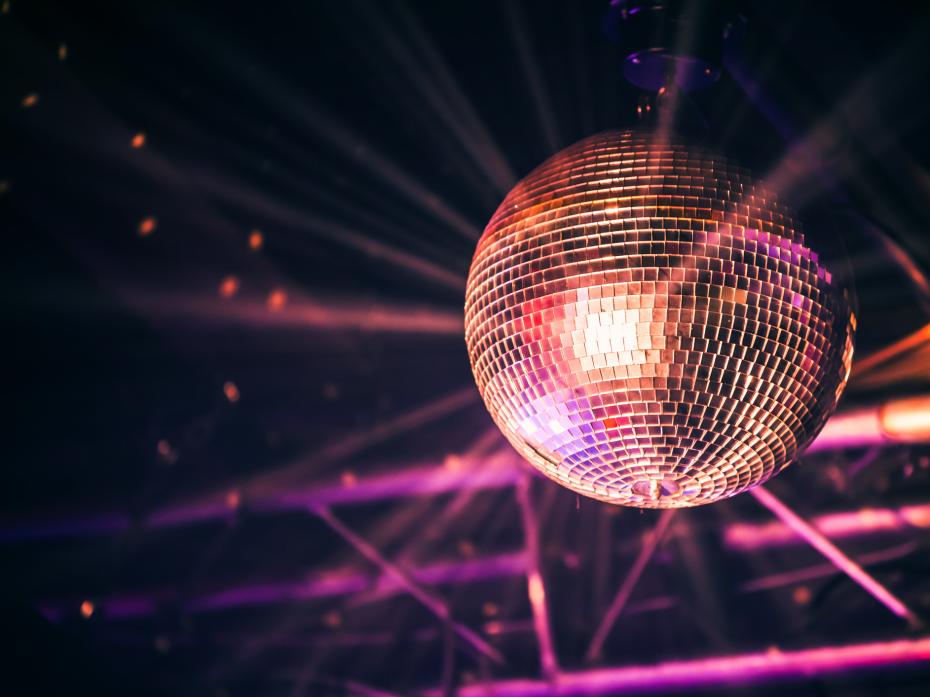 A disco ball suspended from the ceiling of a dimly lit room