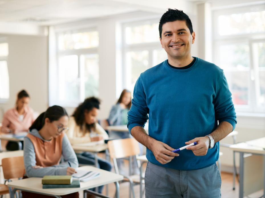 A professor in class smiling to camera