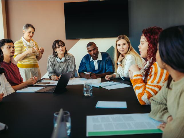 A group of university students sitting around a table having a discussion
