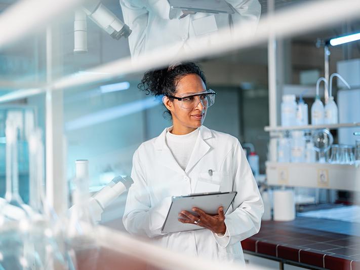Latino female researcher taking notes in a laboratory