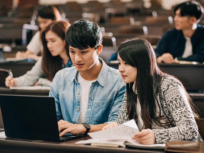Asian students doing pair work in a lecture hall