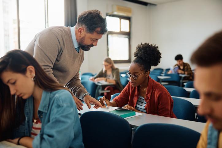 A professor helps a student in class