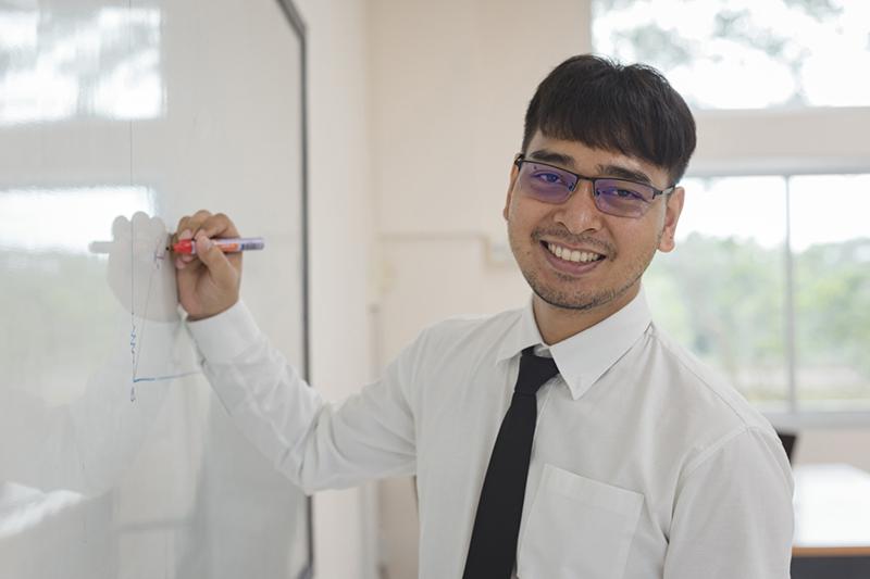 Young male teacher at whiteboard