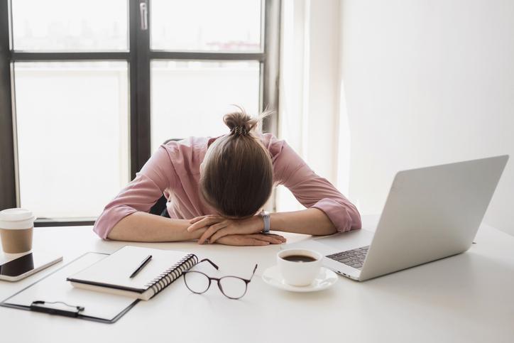 A woman puts her head on the desk