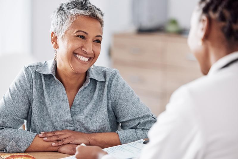 Smiling woman talking to healthcare professional