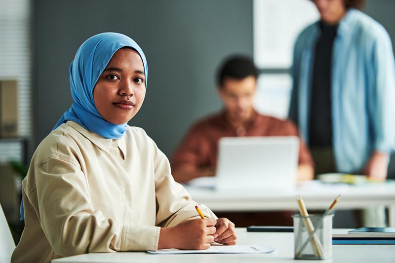 Young Muslim female student in university classroom