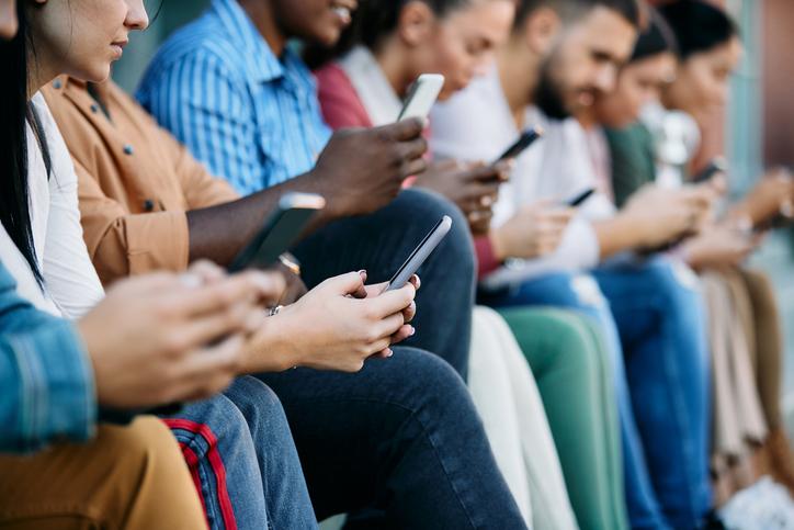A row of people using smartphones