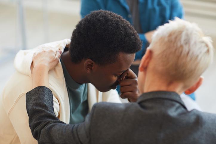 An educator comforts a student