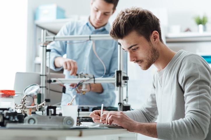 Two researchers make notes while working