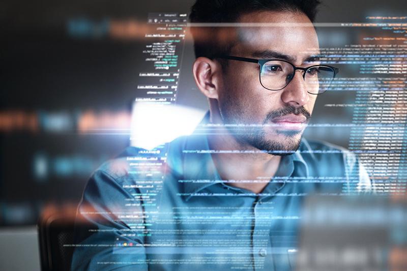 Asian man with glasses looking at screen