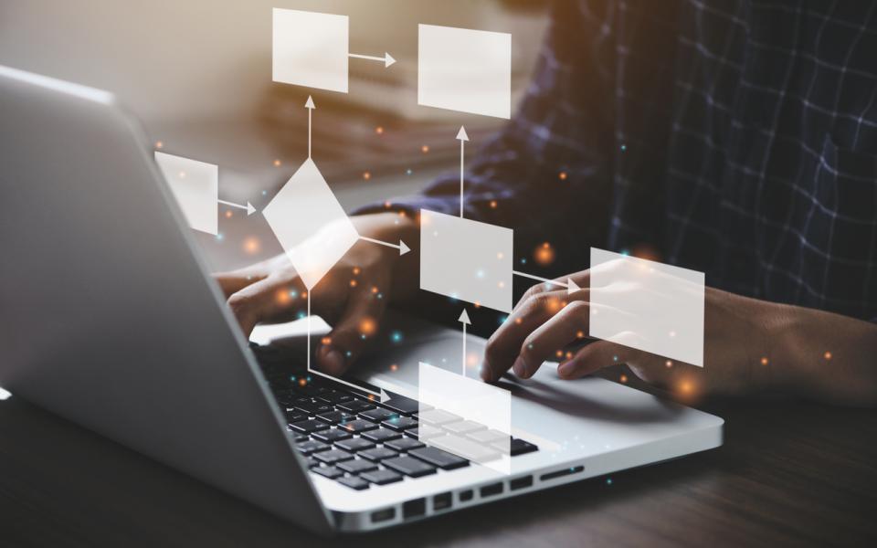 An unseen laptop user with a flow-chart visualisation superimposed