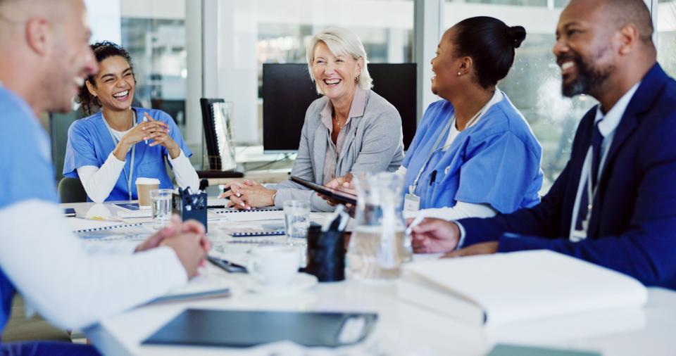 Doctors talking to non-medics around a table