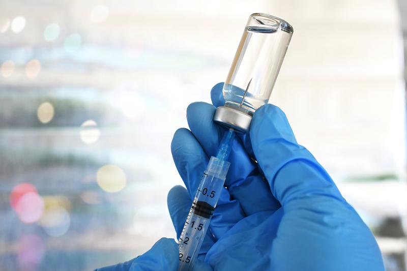 Detail of medic drawing a vaccination shot