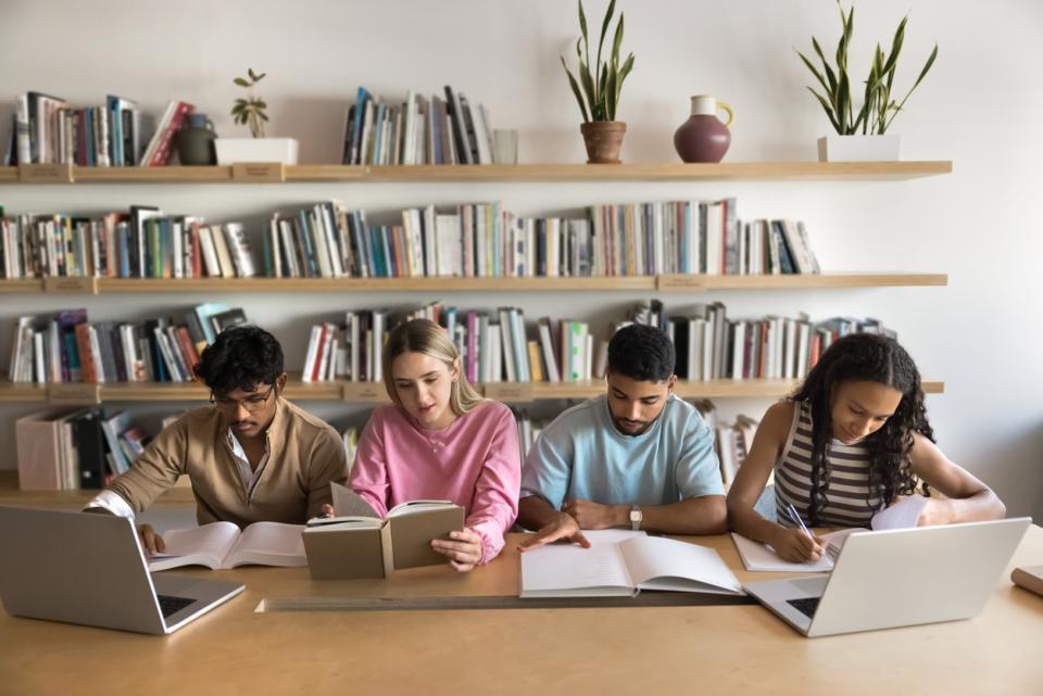 Students work with laptops and books
