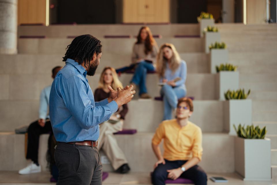 An AI expert presenting in front of room full of staff