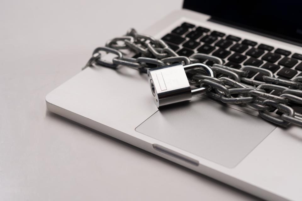 A laptop with a padlocked chain around it