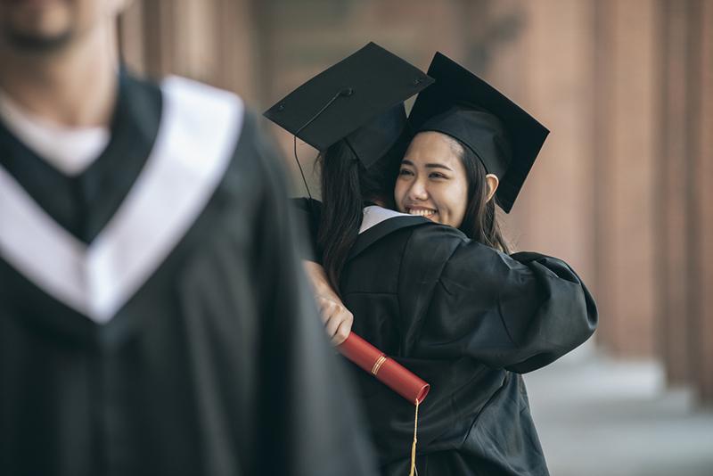 Two female graduates embrace