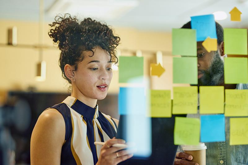 Two professionals using stick notes to plan