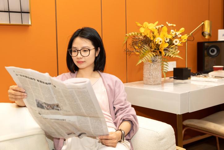A female university student reading a newspaper