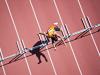 Runner jumping hurdles on track